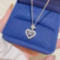 Close-up of a silver-tone heart-shaped bow pendant with clear stones in a blue velvet box - Bowknot Heart Pendant (X395) / Silver