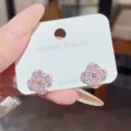Close-up of pink four-petal stud earrings with clear stones on a white display card - Pink Clover (E0571)