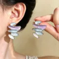 Orecchini asimmetrici a strati, color lavanda, azzurro chiaro e avorio, indossati e mostrati in mano - Orecchini a Bottone Smalto Astratto (0158) / Argento