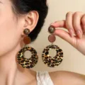 Primo piano di cerchi leopardati con dettagli marroni, indossati e mostrati accanto all’orecchio - Stile Pendente Leopardato Rotondo (M-491)