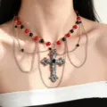 Dettaglio di perline rosse e nere, catene argentate sovrapposte e croce decorata con pietre scure - Croce a Tralcio (S257) / Perline Rosso Nero Stile Croce Retrò
