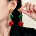 Primo piano di orecchini a fiocco rossi, verdi e dorati, a tre livelli, indossati all’orecchio - Stile Fiocco Triplo Oro Verde Rosso (DZ-893)
