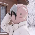 Pink winter trapper hat with integrated face mask, plush ear flaps, and white stripe detail - Pink