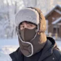 Gorro de invierno marrón estilo aviador con máscara y cubrenuca, usado en un paisaje nevado - Café