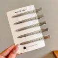 Fünf silberne Metall-Haarclips mit Lochmuster, auf einer weißen Karte präsentiert - 5 Stück/Packung / Silber