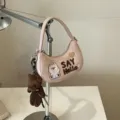 Sac bandoulière rose en demi-lune, avec broderie de chien blanc et breloque ours en peluche brun - Avec Pendentif / Rose