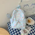 Sac à dos enfant en nylon bleu clair, motifs de chats, donuts et étoiles, présenté à plat - Ours en peluche
