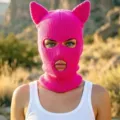 Cagoule rose en tricot avec oreilles de chat et trois ouvertures, portée par un modèle en extérieur - Adulte 56-59 / Rouge Rose Oreilles de Chat 3 Trous