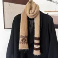 Écharpe en maille camel à flocons brun foncé et rayures, drapée sur une veste noire. - Rayures de Flocons de Neige - Khaki