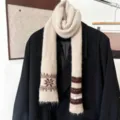 Écharpe en maille crème à motifs de flocons bruns et rayures, posée sur un blazer noir - Rayures de Flocons de Neige - Beige
