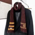 Écharpe en maille bordeaux à rayures moutarde et motifs jacquard présentée sur un manteau noir - Rayures de Flocons de Neige - Café