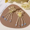 Close-up of cream bead flower earrings with yellow resin blooms, pearls and blue crystal drops - Yellow