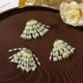 Three fan-shaped ornaments with white rice-shaped beads and green accents on a dark wood tray - Tassel Style / 1 Piece/Pack