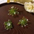 Three green beaded starburst ornaments with red and white accents arranged on a dark wooden tray - Flower Style / 1 Piece/Pack