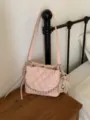 Pink quilted flap bag with a chain-trimmed edge and pearl heart charm, displayed on a wooden table - With Pendant / Pink