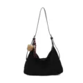 Sac noir souple en demi-lune, avec longue bandoulière et breloque ourson en peluche, vue de face - Sac Seul / Noir