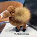 Close-up of a brown plush camel with a fluffy tan hump and dark feet, displayed on a white board - Camel Brown
