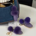 Bottines violettes en breloques, avec pompons et anneaux dorés, près d'un sac en jean - Violet