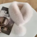 Overhead view of a soft blush-and-white fluffy scarf with a matching pom-pom on a round table - Flesh Pink