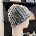 Close-up of the black, white and gray ribbed knit with a fluffy black pom-pom and folded brim - One Size (Elastic) / Frosted Black