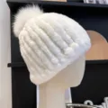 Close-up of a white ribbed plush hat with a fluffy pom-pom, displayed on a mannequin head - One Size (Elastic) / White