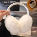 Hand-held view of fluffy white earmuffs, showing the curved headband and soft plush ear pads - White