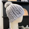 Close-up of a gray plush ribbed hat with a fluffy pom-pom, displayed on a mannequin - One Size (Elastic) / Light Gray