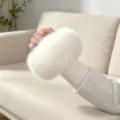 White fluffy fur wrist cuff with a rounded plush shape and ribbed knit opening, shown on a hand - White