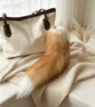 Plush fox-tail bag charm with a golden hook, fading from warm brown to a white tip - Bleached Gold Fox Tail / 38-40cm