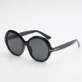 Black oversized round sunglasses with dark gray lenses and gold T-shaped temple accents, angled view - UV400 Protection / Black Frame Grey Lens