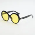 Black round sunglasses with yellow lenses, wide temples and gold T-shaped accents, shown at an angle - UV400 Protection / Black Frame Yellow Lens