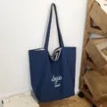 Bolso tote de tela azul marino, con asas a rayas e inscripciones blancas «beyou» y «merci» - 46*14*37 / Azul