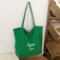 Bolso tote verde de lona, con asas largas para el hombro y texto blanco «beyou merci» al frente - 46*14*37 / Verde