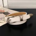 Schmaler weißer Damengürtel aus Kunstleder mit matter silberner Dornschließe, locker gerollt - Einheitsgröße / Weiß