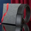Schwarzer Herrengürtel aus genarbtem Leder mit glänzender Automatikschließe neben einer Geschenkbox - Schwarzer Automatikgürtel (Mit Geschenkbox) / 110cm