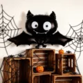 Halloween display with a smiling black bat balloon, wide wings, spiderwebs, wooden crates and pumpkins - Bat Foil Balloon / 2pcs Pack (72cm*60cm)