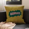 Samtiges olivgrünes Kissen mit pinkem „BRAVO!“-Aufdruck, auf einem dunklen Ledersofa arrangiert - 35x35cm (Nur Bezug) / Gelb BRAVO (SBZA297902)
