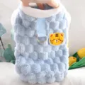 Primo piano di un gilet in morbido peluche azzurro a quadri, con collo bianco, anello e toppa tigre - Taglia S / Tigre Blu