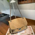 Detail view of a camel suede quilted flap bag with a silver chain strap and turn-lock clasp - 30x11x20cm / Camel