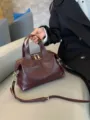 Burgundy leather Boston bag with top handles, adjustable crossbody strap and gold-tone hardware - 30x13x22cm / Wine Coffee