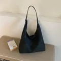 Sac cabas noir à texture tressée, forme souple, longue bandoulière et fermeture par cordon - Sans pendentif / Noir