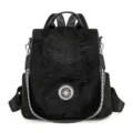 Women's black convertible backpack with soft matte fabric and round metal front ornament - Black