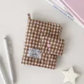 Detalle del tejido acolchado a cuadros, con broche rosa de presión en forma de corazón - Sin Páginas Interiores / Marrón