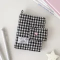 Vista cenital de una funda acolchada de cuadros blancos y negros, con cierre de corazón rosa y asa - Sin Páginas Interiores / Negro