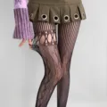 Close-up of black fishnet tights with oval cutouts, floral lace panels and vertical mesh stripes - One Size / Bottoms / Black
