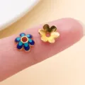 Gros plan sur deux pièces florales, l’une émaillée en bleu, l’autre dorée, avec un trou central. - Calotte Fleur à Six Pétales (28574)