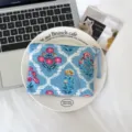 Pochette zippée en coton bleu, ornée de motifs floraux rouges et jaunes et d’un pompon tressé - Grappe Florale Bleue