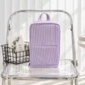 Purple and white striped quilted zippered bag with a top handle, displayed on a clear chair - Purple