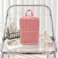 Red-and-white striped fabric bag with a top handle and zipper, upright on a clear chair - Red