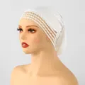 Vista laterale di un copricapo bianco in maglia su un manichino, con bordo decorativo in pizzo - 30*23cm / Bianco